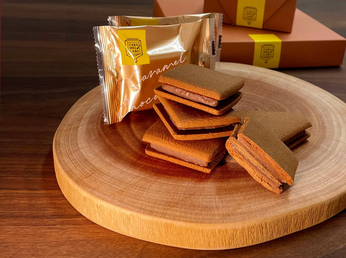 断面から層が見えるキャラメルショコラサンドと金色のパッケージ