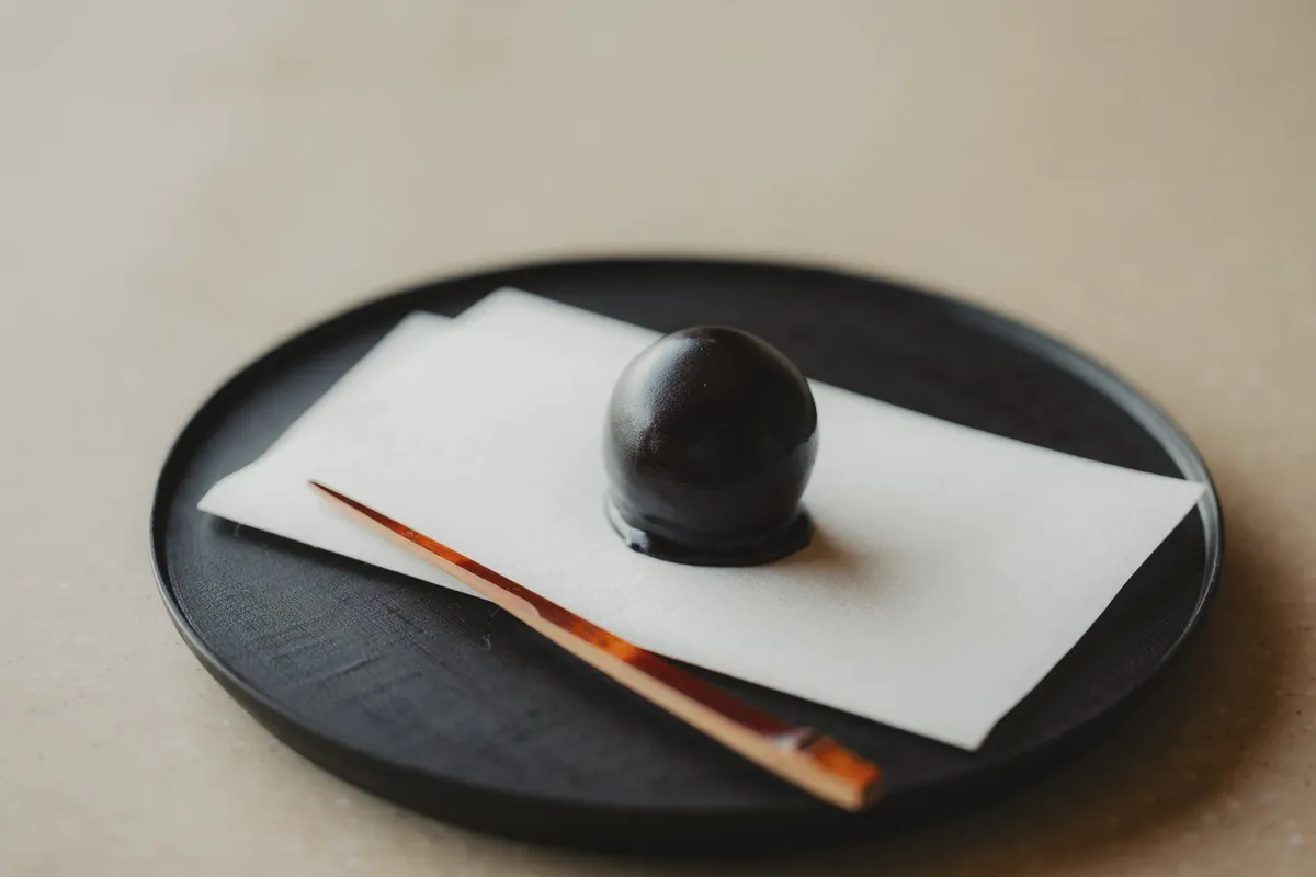 黒い器にのせられた一玉のくろ玉。洗練された和の佇まいを感じさせます