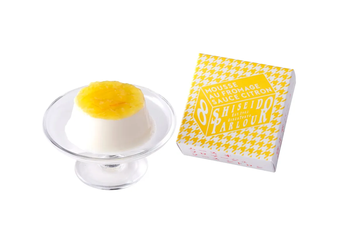 白い背景に置かれた上品なチーズムースと千鳥格子柄の箱