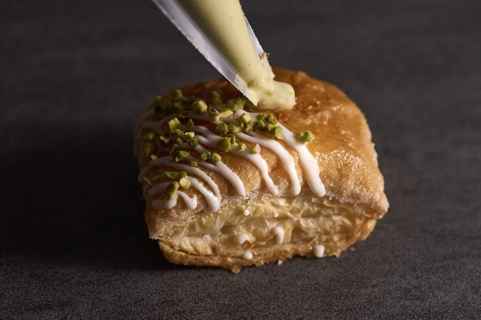 焼き上がったパイ生地にクリームを丁寧に注入する工程