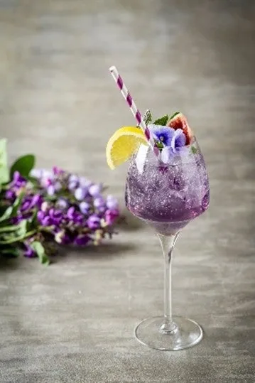 無花果とエディブルフラワーを添えた、ライラック色の美しいシーズナルドリンク