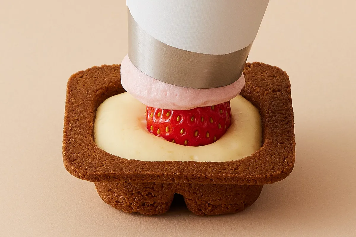 苺の上に生チーズムースを絞り出す工程