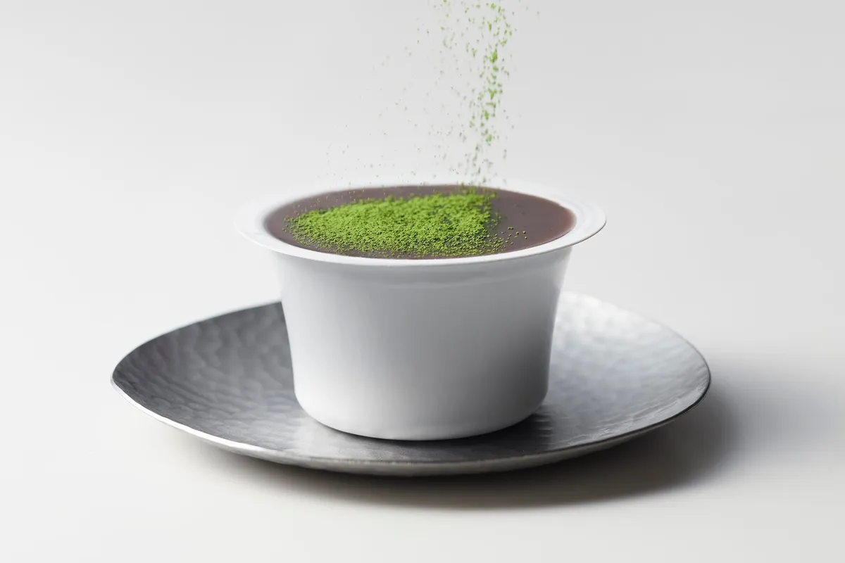 本生羊羹に鮮やかな抹茶をふりかける様子