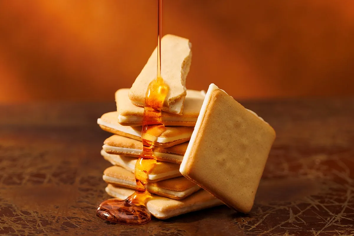 積み上げられたクッキーに流れる黄金色のメープルシロップ