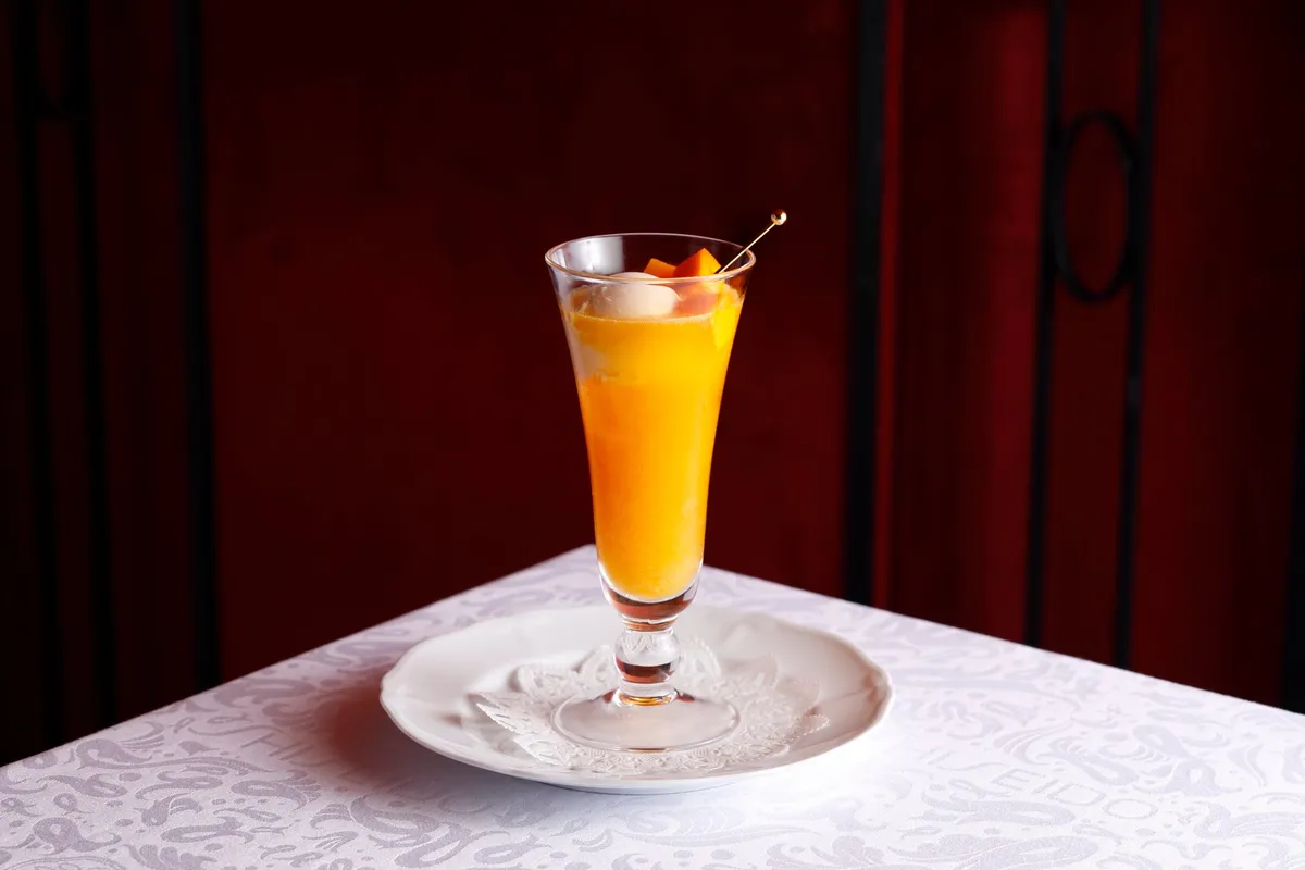 鮮やかなオレンジ色のマンゴーソーダにバニラアイスが乗ったアイスクリームソーダ