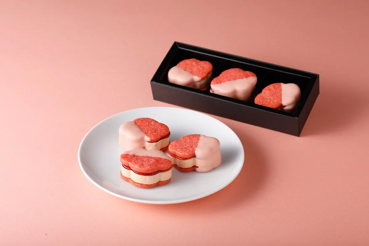 椿の形をした苺味のサブレにピンクのチョコレートがコーティングされたサンド菓子
