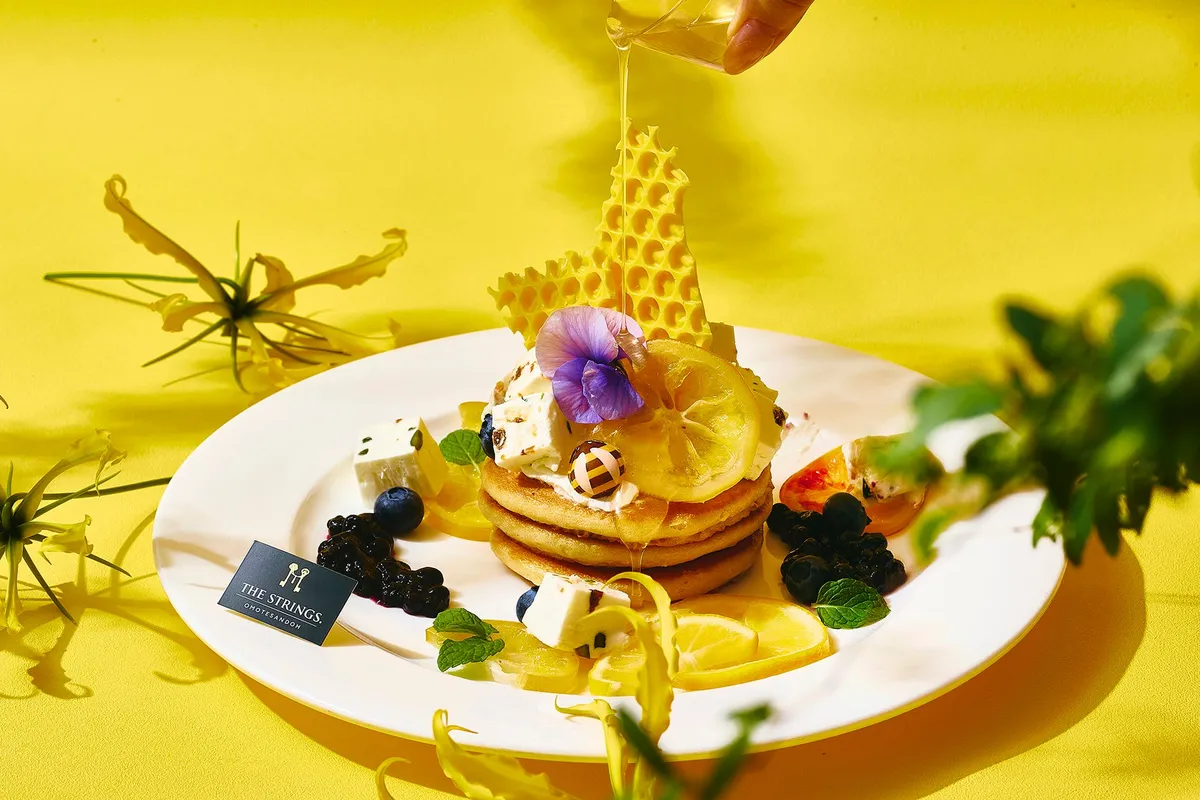 パンケーキにはちみつをかける様子