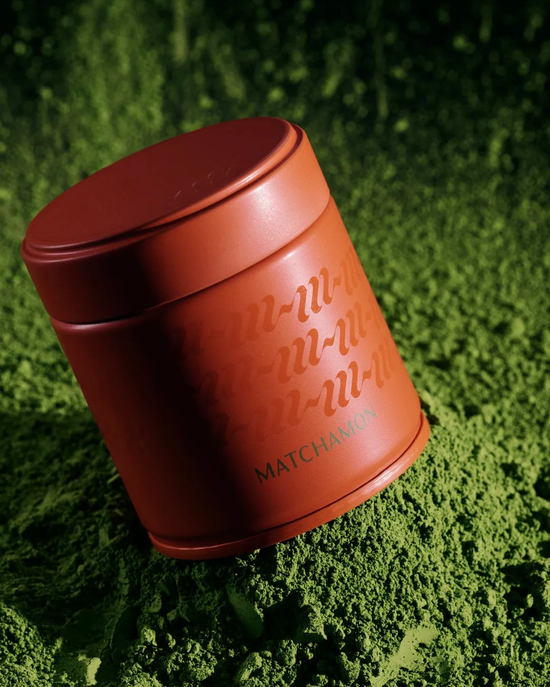 たっぷりの抹茶パウダーの上に置かれた赤い茶筒