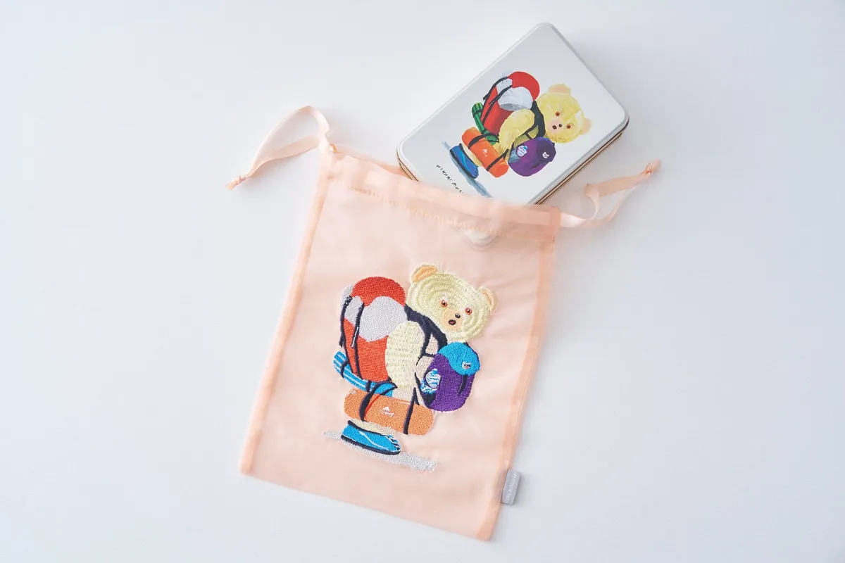くまちゃんの刺繍が施されたオーガンジー巾着とビスケット缶
