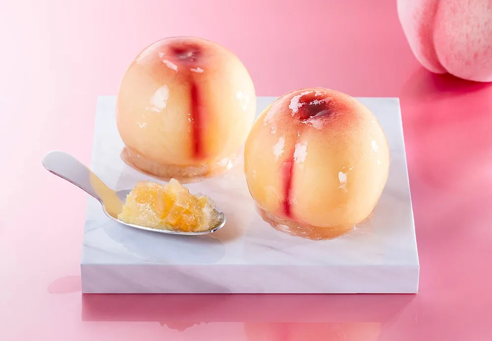 大理石の上に並んだつやつやと輝く2つの桃ケーキ