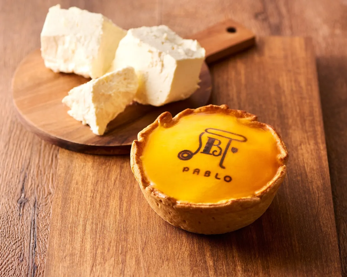 パブロの新作11cm小さいサイズ。木目調のボードにのった美味しそうなチーズタルト