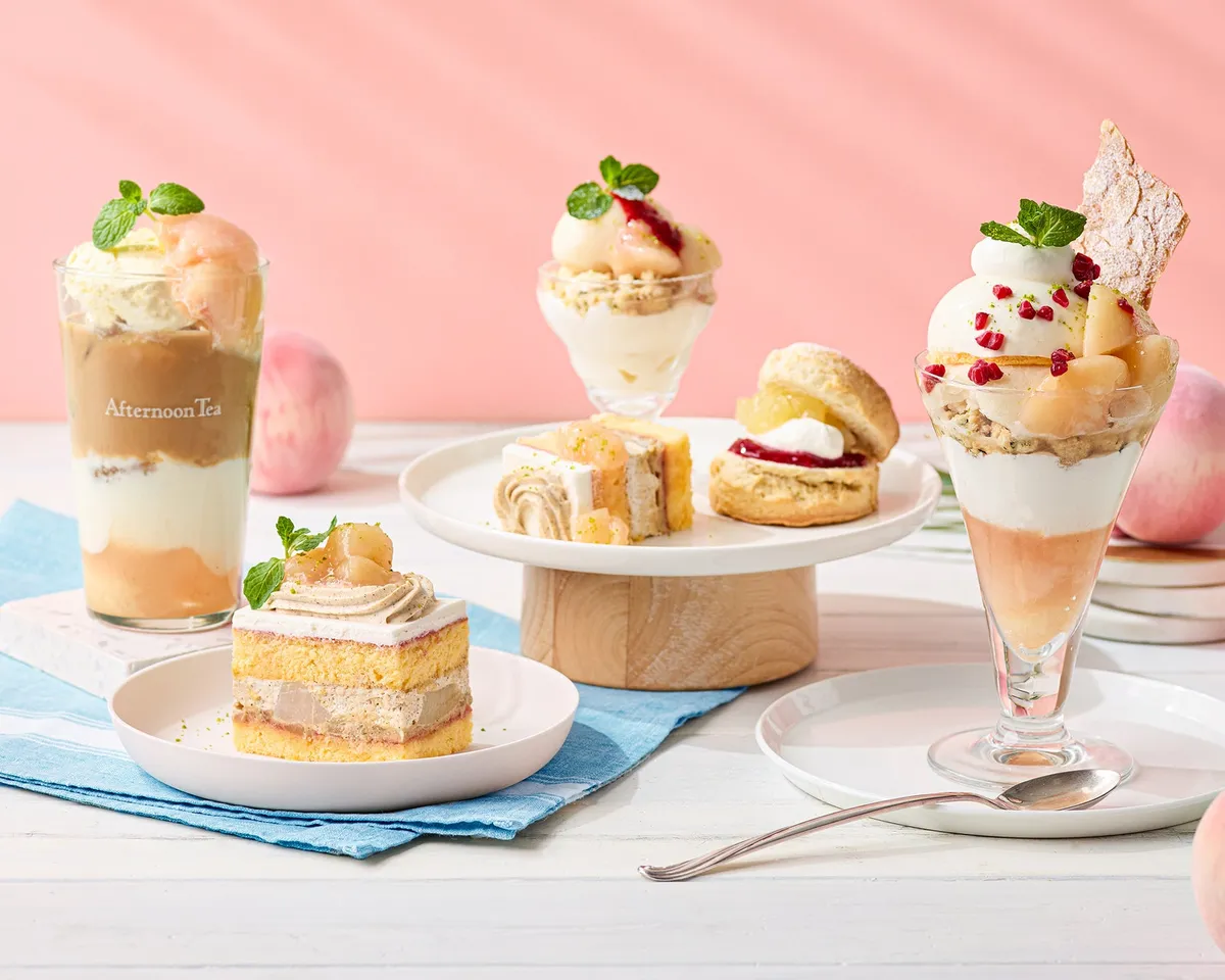 白桃のパフェやショートケーキ、ティーが並ぶ華やかなテーブル