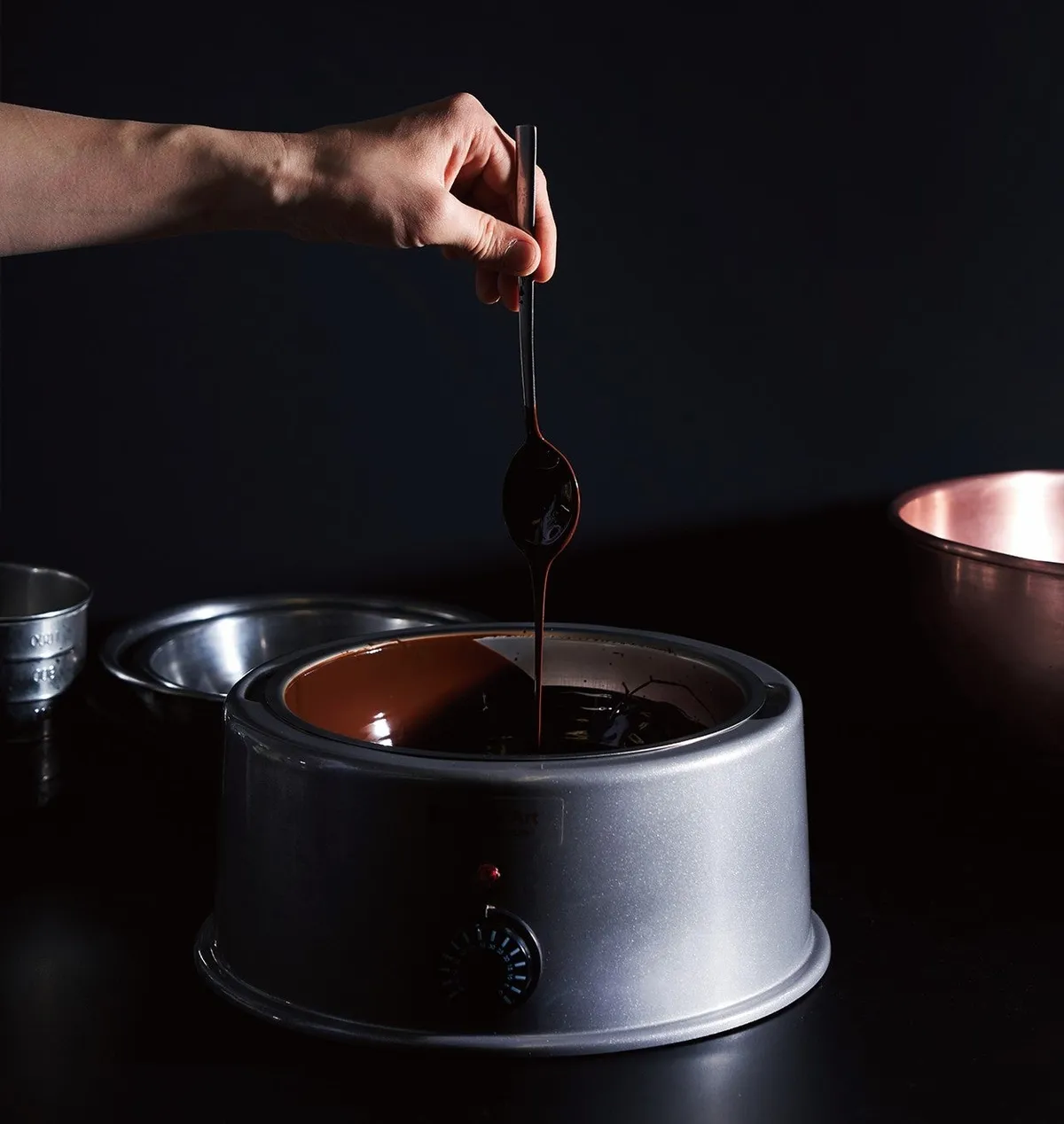 チョコレートを丁寧にテンパリングする職人の手元