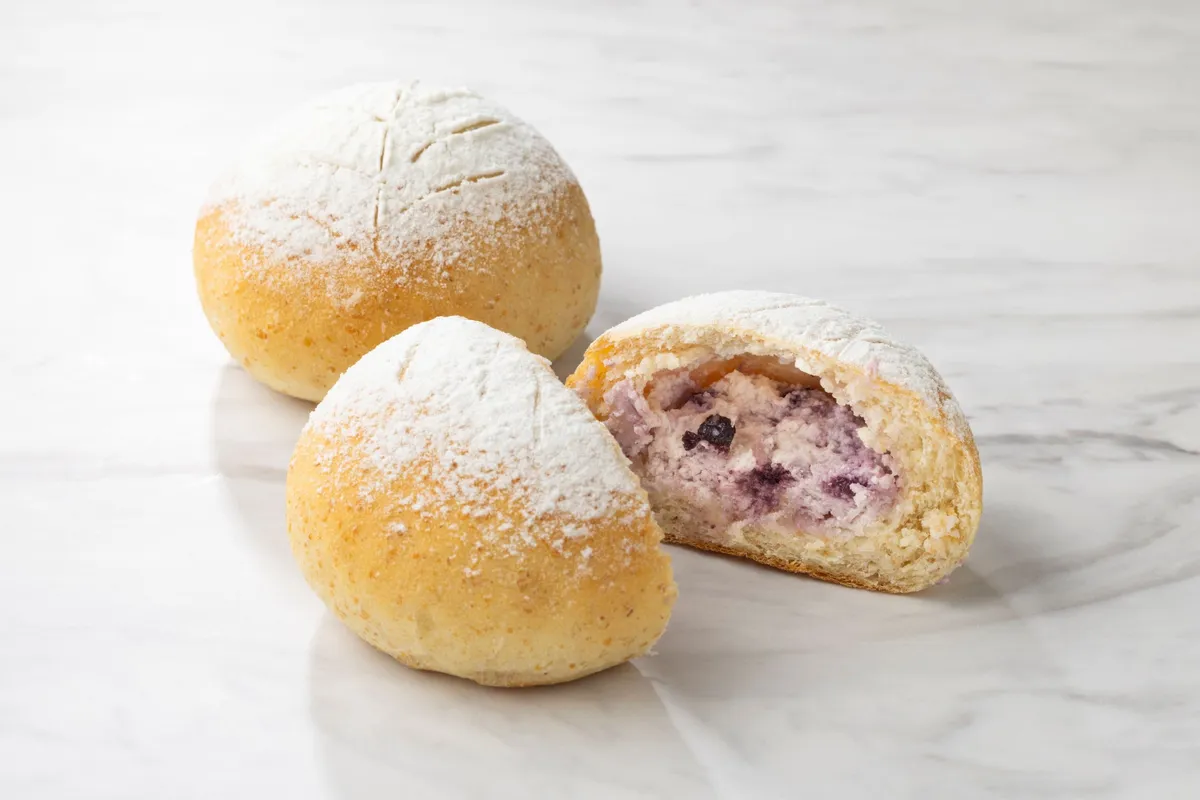 白い粉糖がかかったパンの中にブルーベリークリームチーズが詰まった断面
