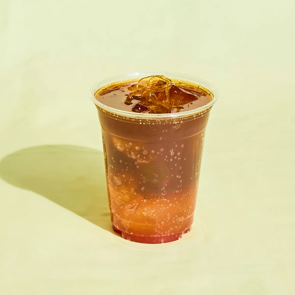 オレンジの層とコーヒーのグラデーションが映える炭酸ドリンク