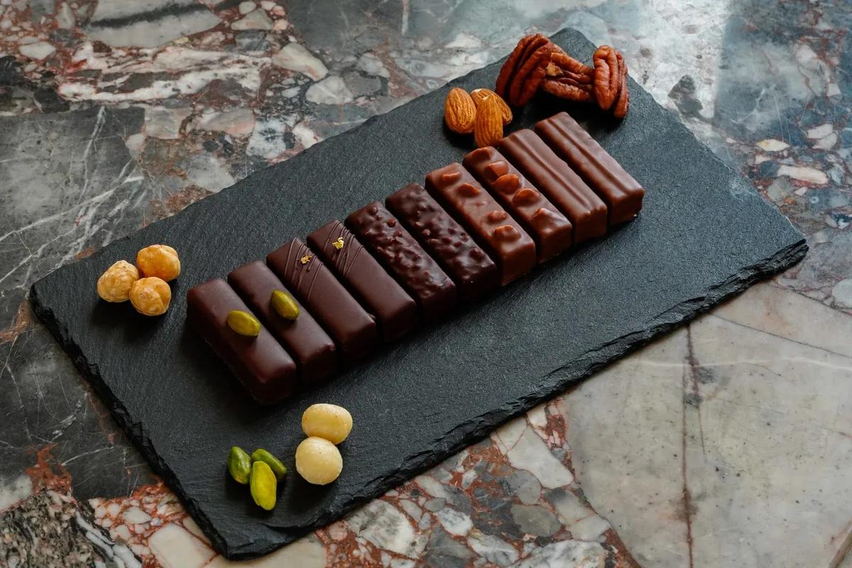 5種のナッツのプラリネ・アソート。黒いプレートに並んだスタイリッシュなチョコバー