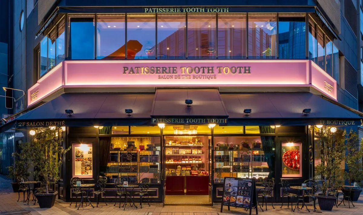 夜の街にピンクのネオンが映えるPATISSERIE TOOTH TOOTHの店舗外観
