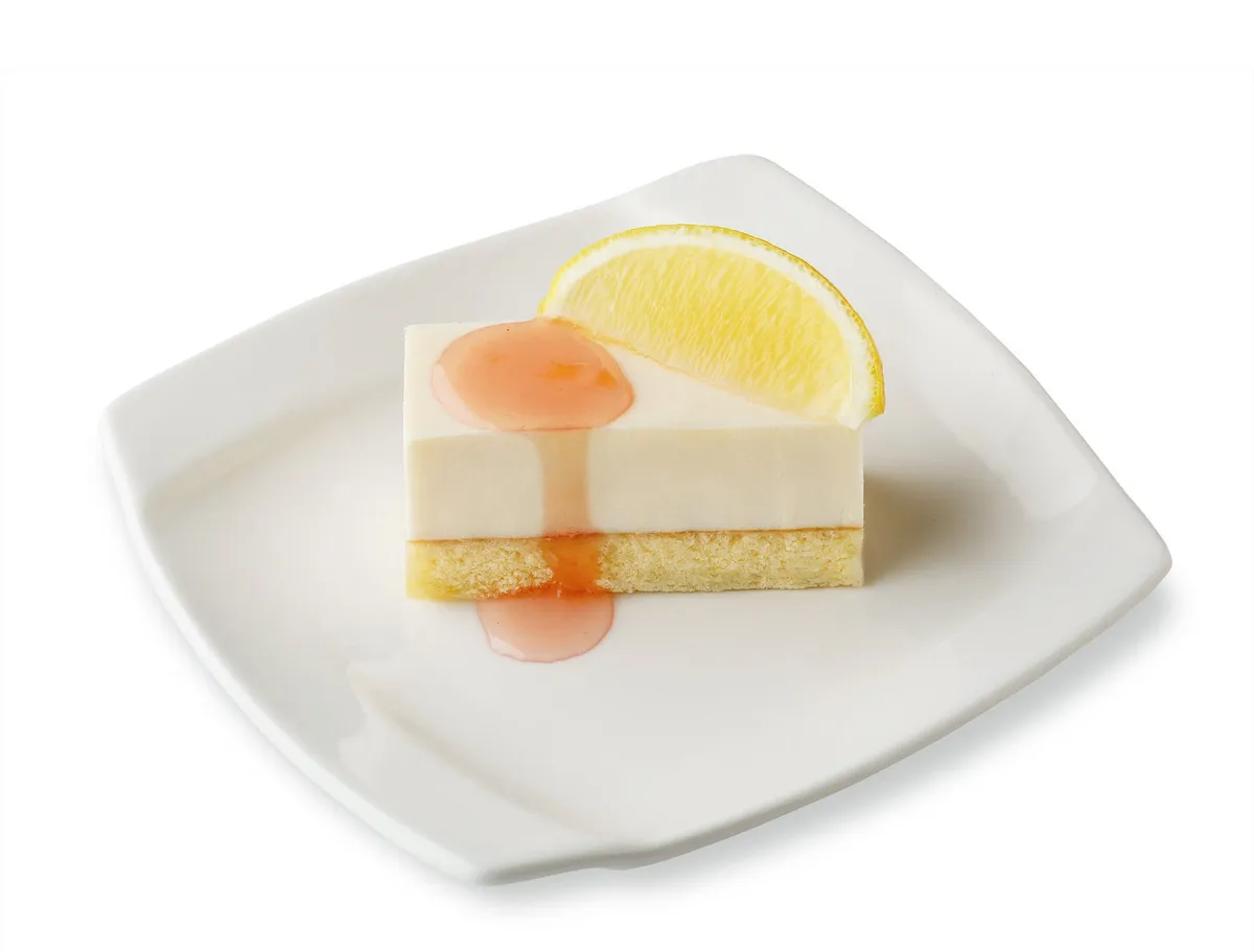 レアチーズケーキに白桃シロップがかかり、カットレモンが添えられた夏らしい一皿