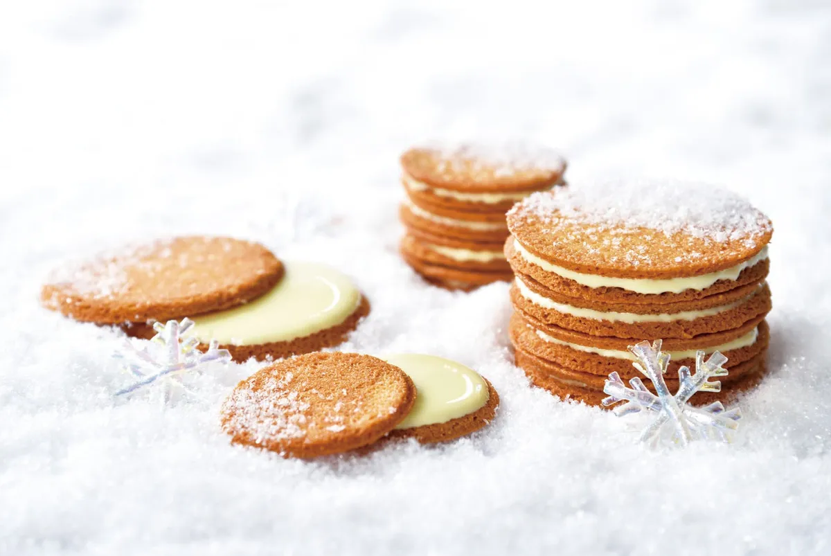 雪の上に並べられた香ばしいき花のガレットとホワイトチョコ