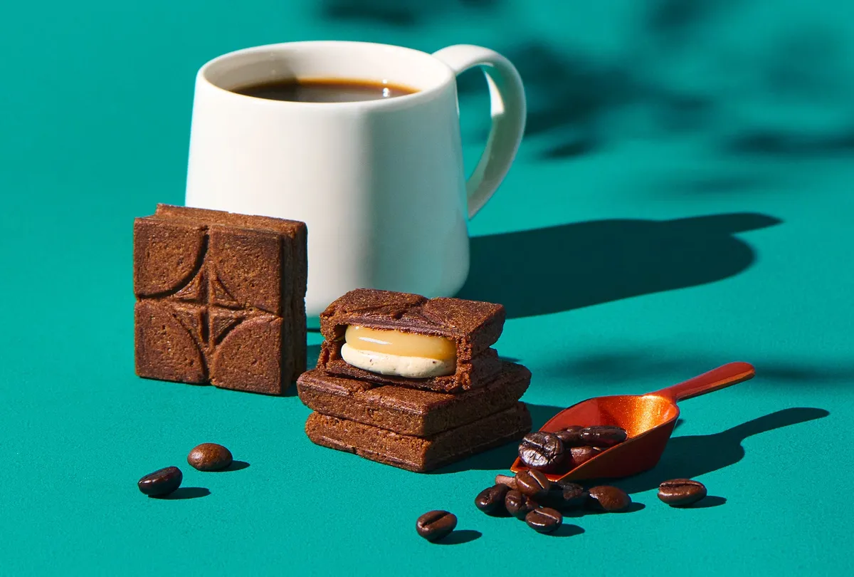 2層のクリームがたっぷり詰まったバターサンド〈珈琲〉の断面とコーヒーカップ
