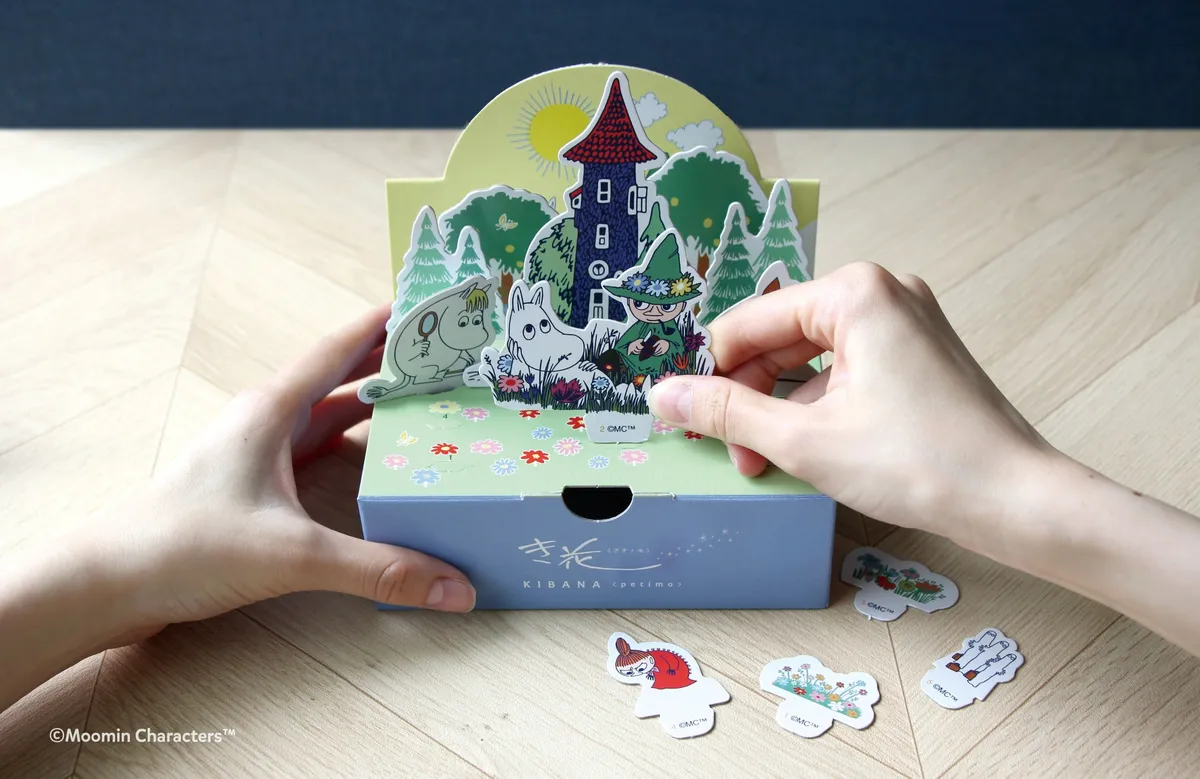 ムーミンたちのキャラクターパーツをパッケージに差し込んで組み立てる様子