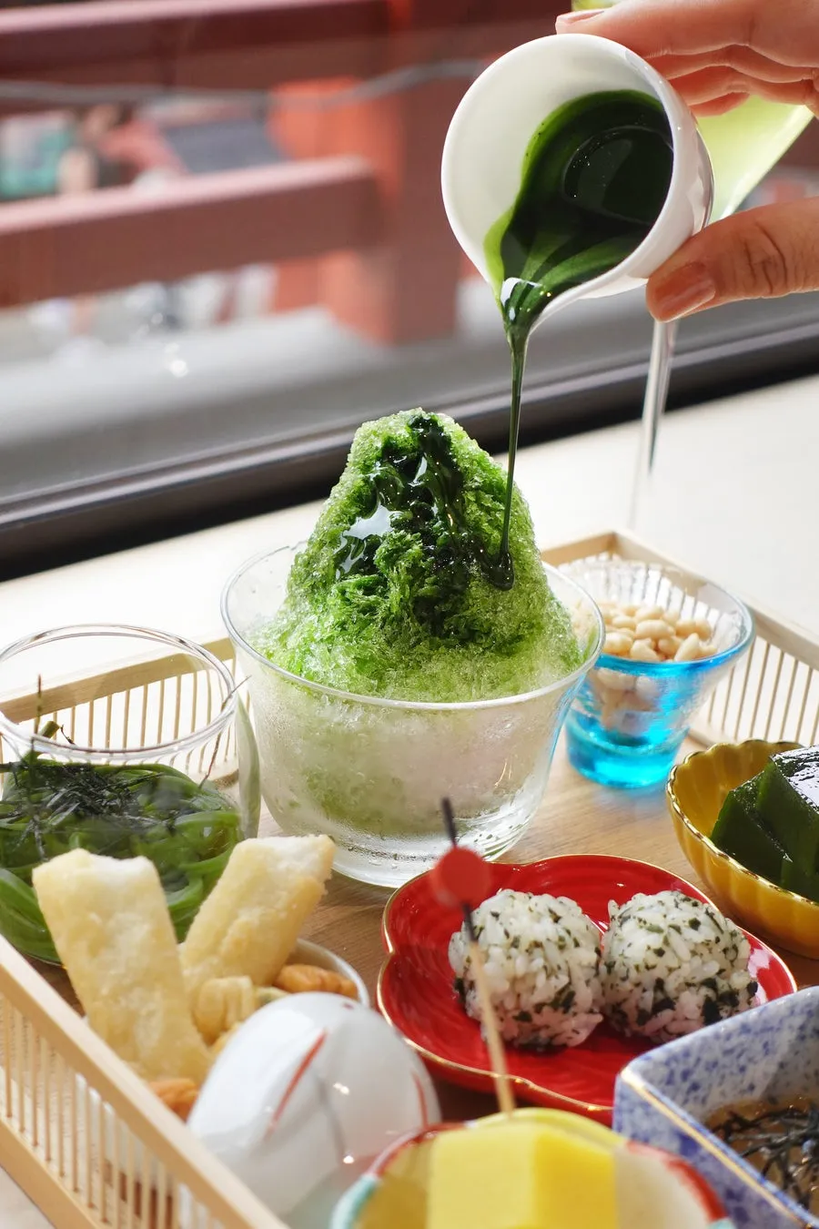 かき氷に抹茶ソースをかける様子