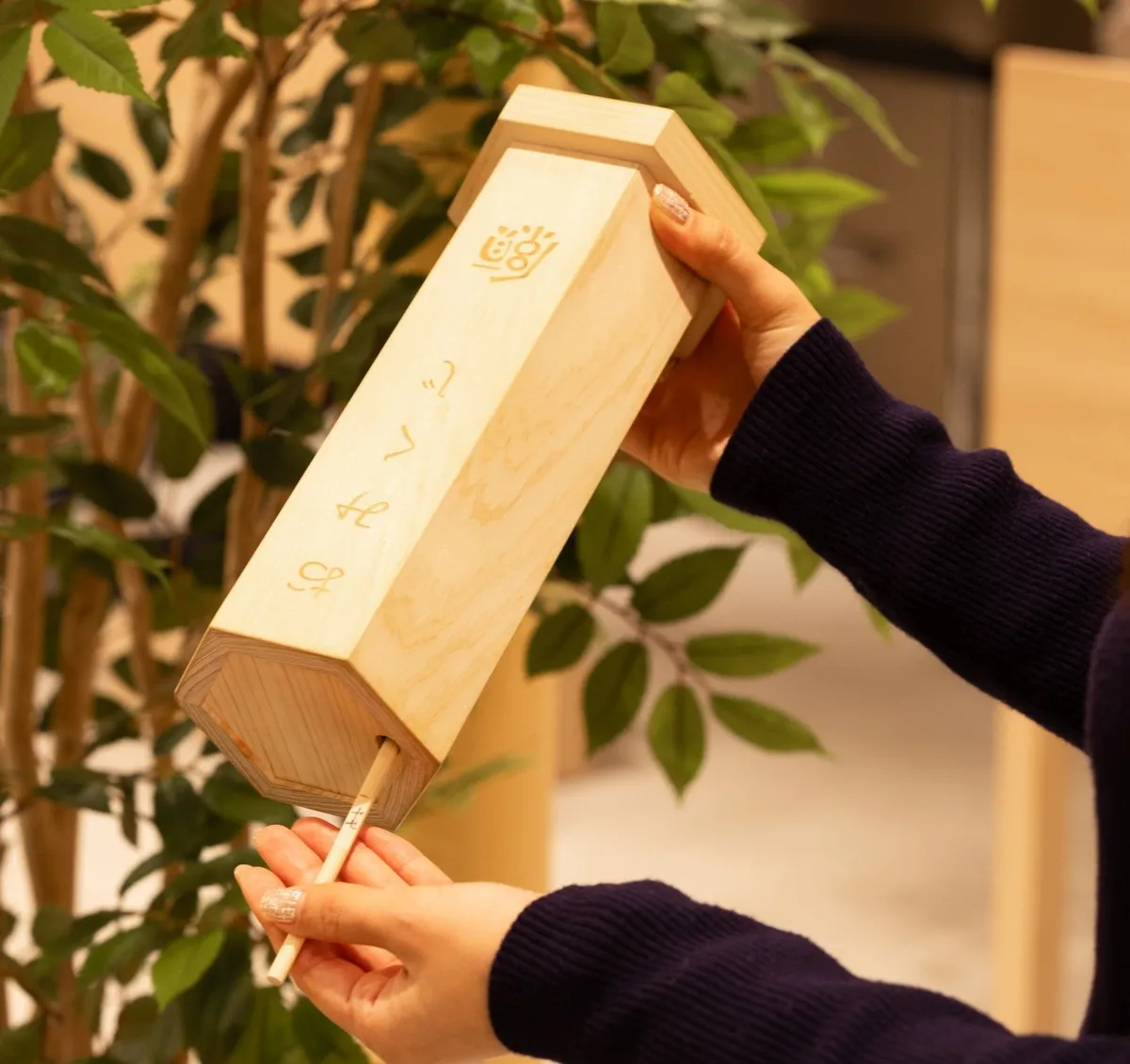 木製の箱からおみくじを引くワクワクの瞬間