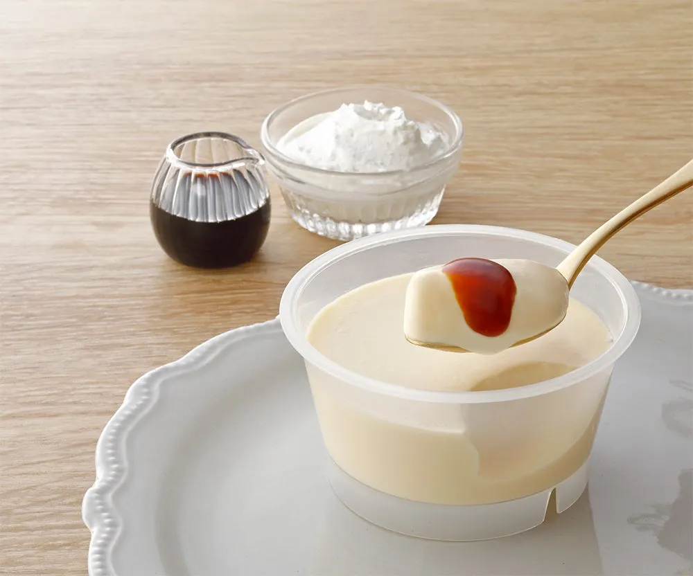 スプーンですくったとろプリンと別添のカラメルソース